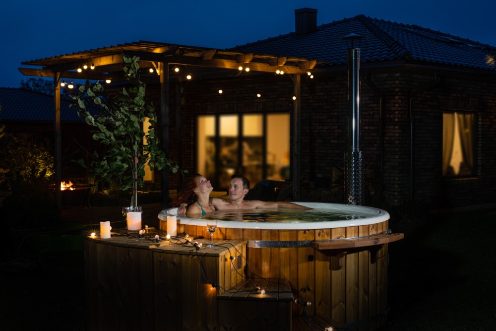 couple in woord burning hot tub in the night