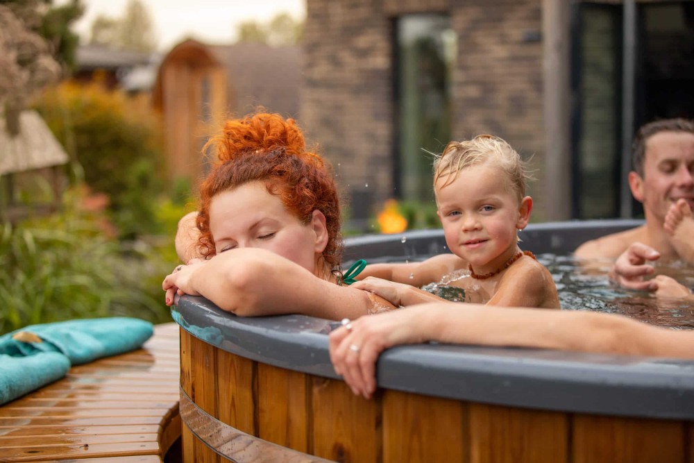 woman bathing in wood burning hot tub with closed eyes