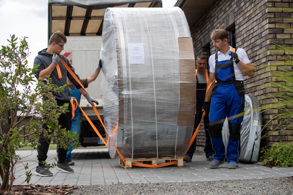 man preapring to carry wood burning hot tub on pallet